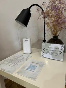 a desk with a lamp and a book and a vase with flowers at 14 берёз in Borovoye