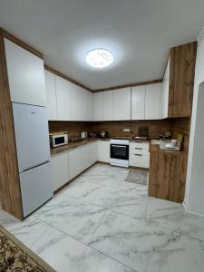 a large kitchen with white cabinets and appliances at 14 берёз in Borovoye
