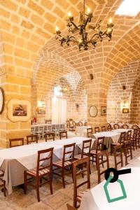 a dining room with tables and chairs in a building at Hotiday Torre Guaceto in Brindisi