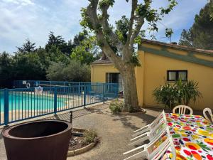 a table and a tree in front of a fence at Philippe in Beaurecueil