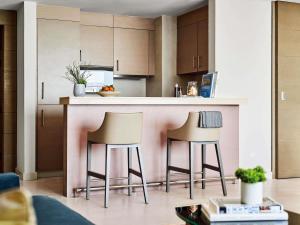 a kitchen with two bar stools at a counter at Pullman Doha West Bay in Doha
