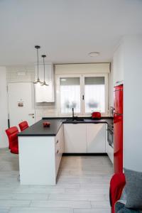 a kitchen with white cabinets and red appliances at Loft A la verita River,PARKING PRIVADO GRATIS in Córdoba