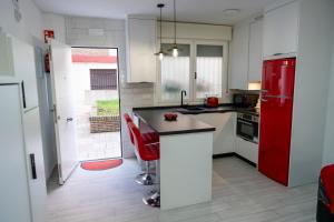 a kitchen with white cabinets and a red refrigerator at Loft A la verita River,PARKING PRIVADO GRATIS in Córdoba