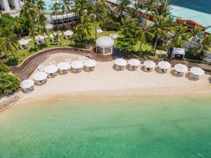 an aerial view of a beach with chairs and umbrellas at Mövenpick Hotel Mactan Island Cebu in Mactan