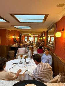 a group of people sitting at tables in a restaurant at Gatsby Hotel - Adults Only - Restaurant - Small Luxury Hotel by F-Hotels in Blankenberge