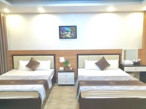 a hotel room with two beds and a television at Hotel Vân Anh in Hanoi