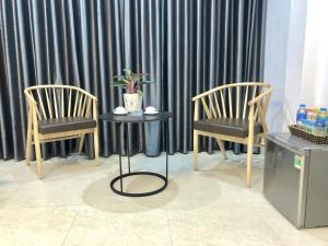 two chairs and a table in front of a window at Hotel Vân Anh in Hanoi