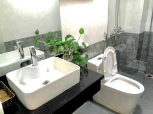 a bathroom with a sink and a toilet and a mirror at Hotel Vân Anh in Hanoi