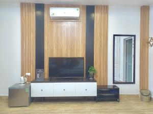 a living room with a television on a white cabinet at Hotel Vân Anh in Hanoi