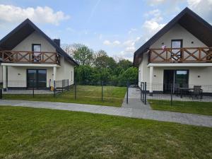 a white house with a playground in front of it at Mazurska Osada in Januszkowo