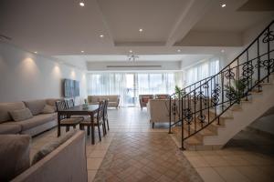 a living room with a staircase and a table and chairs at Blue Star Villa in Durat Alarous