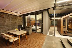 a living room with a table and chairs and a bedroom at 브라운도트호텔동탄역점 구 js더클래식호텔 in Hwaseong +210 photos