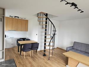 a kitchen and dining room with a spiral staircase in a apartment at Mazurska Osada in Januszkowo