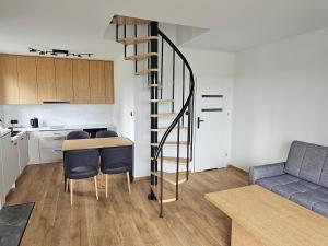 a kitchen and a living room with a spiral staircase at Mazurska Osada in Januszkowo
