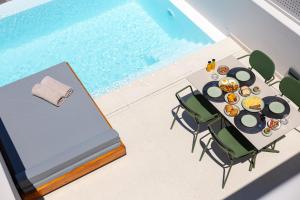 a table with food and chairs next to a swimming pool at Evira Suites in Pyrgos