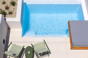 two chairs sitting next to a swimming pool at Evira Suites in Pyrgos