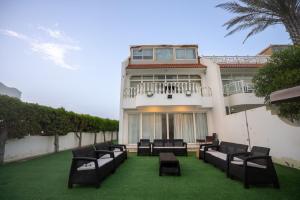 a building with a bunch of chairs on the lawn at Blue Star Villa in Durat Alarous