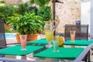 a table with four different colored drinks in glasses at Can M Tatau in Santanyi