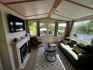 a living room with a couch and a fireplace at Devon Tor View Country Retreat in Bratton Clovelly