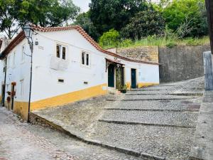 a building on a cobblestone street with stairs at Pé do Castelo Casinhas in Tomar