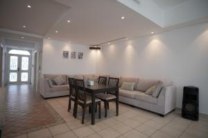 a living room with a couch and a table and chairs at Blue Star Villa in Durat Alarous