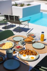 a table with plates of breakfast food on it at Evira Suites in Pyrgos