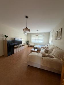 a living room with a large bed and a flat screen tv at Casa Puerta de Toledo, a 8 minutos de Puy du Fou in Cobisa