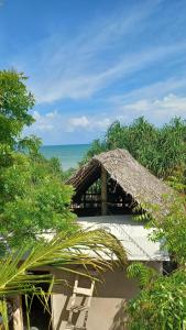 a resort with a straw umbrella and the ocean at Waves ranna cabana and seafood in Ranna