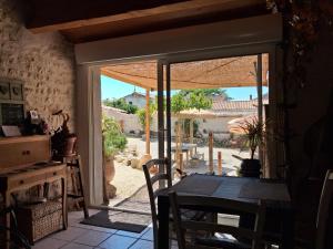 a dining room with an open door to a patio at Chambres D'hôtes La Marouette in Hiers-Brouage