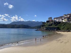 a group of people walking on the beach at La casina de La Fragua in Lastres +3 photos