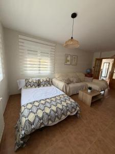a bedroom with a bed and a couch at Casa Puerta de Toledo, a 8 minutos de Puy du Fou in Cobisa +22 photos