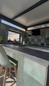 a kitchen with a counter with a chair in it at Casa Puerta de Toledo, a 8 minutos de Puy du Fou in Cobisa
