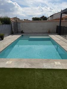 a swimming pool with blue water in a backyard at Casa Puerta de Toledo, a 8 minutos de Puy du Fou in Cobisa