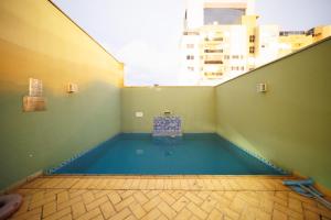 a swimming pool in a room with a view of a building at Cinema no Quarto: Smart TV 65", Piscina e Colado no Shopping! in Joinville