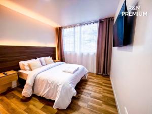 a bedroom with a bed and a tv on a wall at Estancia Exclusiva R&M in Pelileo