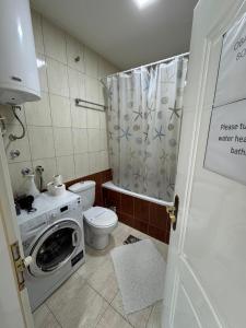 a bathroom with a washing machine and a toilet at M&G centar grada in Požarevac +21 photos
