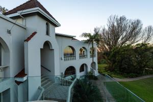 a white house with a staircase leading up to it at Mountain View International Hotel - Eswatini in Mbabane