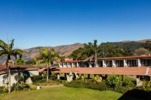 a resort with palm trees and mountains in the background at Mountain View International Hotel - Eswatini in Mbabane