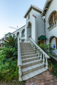 a white house with stairs in front of it at Mountain View International Hotel - Eswatini in Mbabane