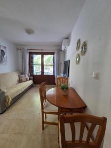 a living room with a table and chairs and a couch at Appartement calme et confort in La Florida