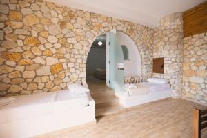 a room with two beds and a stone wall at Vila Dena in Vlorë +282 photos