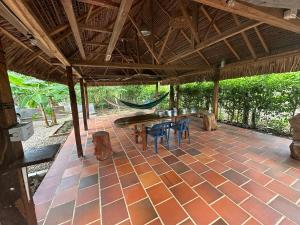 a patio with a table and chairs and a hammock at El descanso del sol llanero in San Luis de Palenque