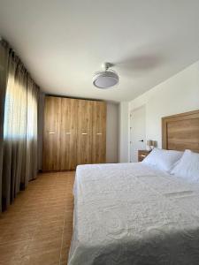 a bedroom with a large bed and wooden cabinets at Apartamentos La Janda in Benalup Casas Viejas +16 photos