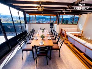 a dining room with a table and chairs and windows at Estancia Exclusiva R&M in Pelileo +13 photos