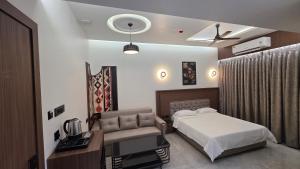 a hotel room with a bed and a desk at Sky Grand Stays in Ulhāsnagar