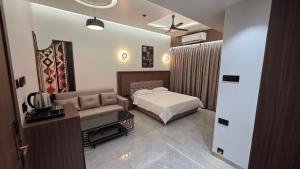 a hotel room with a bed and a couch at Sky Grand Stays in Ulhāsnagar
