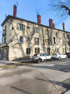 two cars parked in front of a large building at Appart cosy mansardé Dijon gare 1km animaux acceptés in Dijon