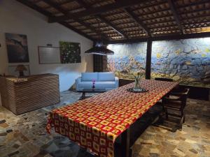 a living room with a table and a blue chair at Pousada Hope Club in Beberibe