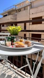 a white table with a plate of food on it at Chez Moi Tropea Centro in Tropea