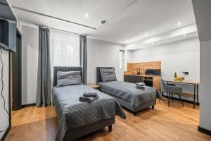 a bedroom with two beds and a desk at Central Platinum Apartments 10 in Rybnik